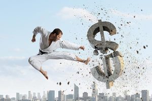 man using martial arts to kick a dollar sign in half showing the true cost of martial arts classes