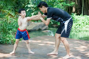 a man becoming a better father by training martial arts with his son in a backyard