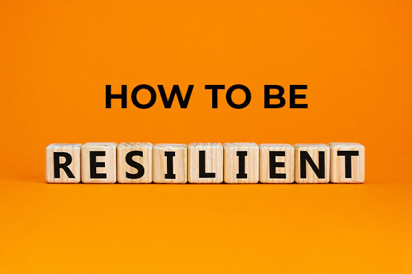 the words "how to be resilient" in front of an orange background. the word "resilient" is spelled with scrabble letter pieces