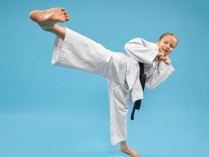 black belt martial artist dressed in gi demonstrating all 6 ways to improve kicking technique