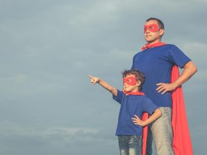 a father and son dressed as superheros