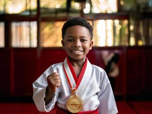 a young martial arts student with a gold medal happily achieving their goals to kick in the new year