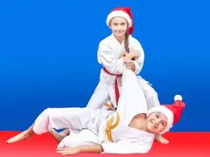 two young students practicing martial arts in santa hats, showing their perseverance to staying committed through the holidays