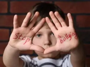 a young boy with the words "stop bullying" written on the palms of his hands